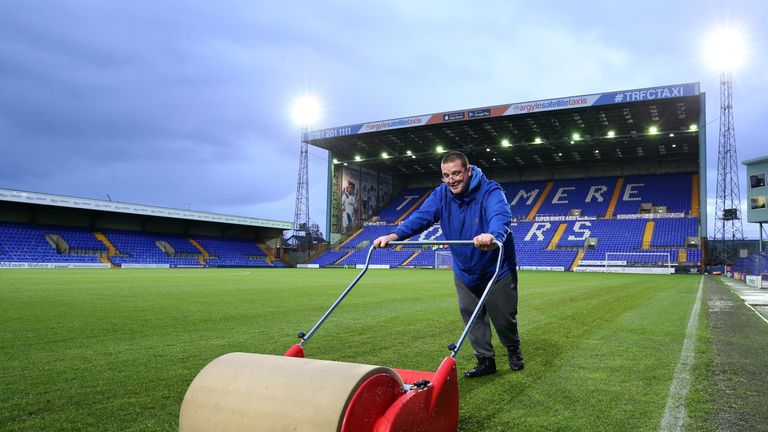 A Tranmere Rovers groundsman tries to clear water from the Prenton Park 
