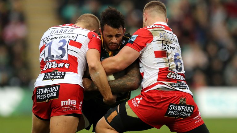 Courtney Lawes is tackled by Chris Harris (L) and Ruan Ackermann 