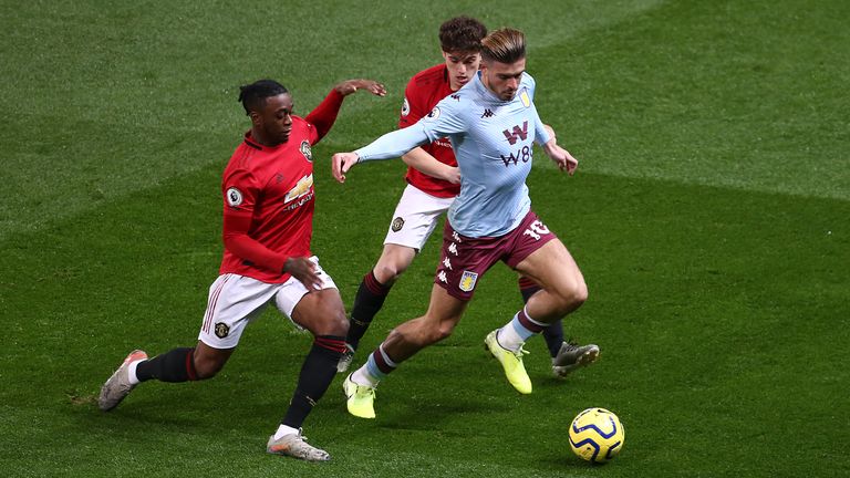 Grealish tries to evade Manchester United duo Aaron Wan-Bissaka and Daniel James