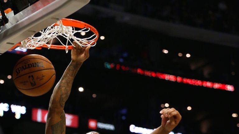 Kawhi Leonard, de Los Angeles Clippers, sumerge el balón como Rui Hachimura, de los Washington Wizards.