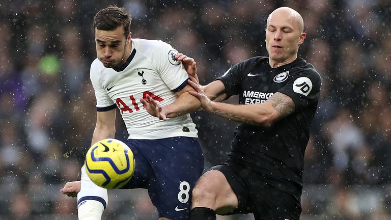 Harry Winks is challenged by Aaron Mooy