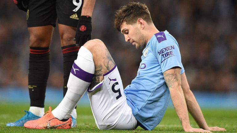 John Stones sits on the pitch after picking up an injury