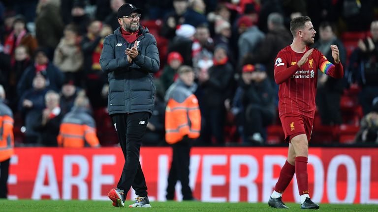 Liverpool's German manager Jurgen Klopp (L) and Liverpool's English midfielder Jordan Henderson applauds the fans following the English Premier League football match between Liverpool and Everton at Anfield in Liverpool, north west England on December 4, 2019. - Liverpool won the match 5-2. 