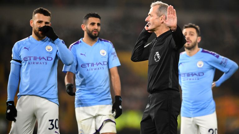 Martin Atkinson speaks with Stockley Park officials before VAR overturns his penalty decision