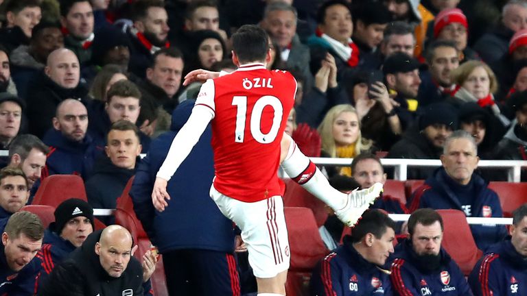 Mesut Ozil of Arsenal kicks a water bottle as he is subbed as Interim Manager of Arsenal, Freddie Ljungberg looks on during the Premier League match between Arsenal FC and Manchester City at Emirates Stadium on December 15, 2019 in London, United Kingdom. 