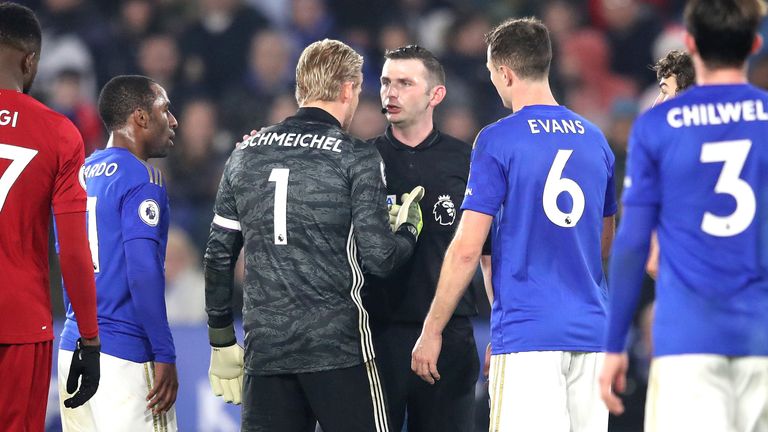 Kasper Schmeichel and other Leicester players remonstrate with Michael Oliver after the penalty award against Caglar Soyuncu