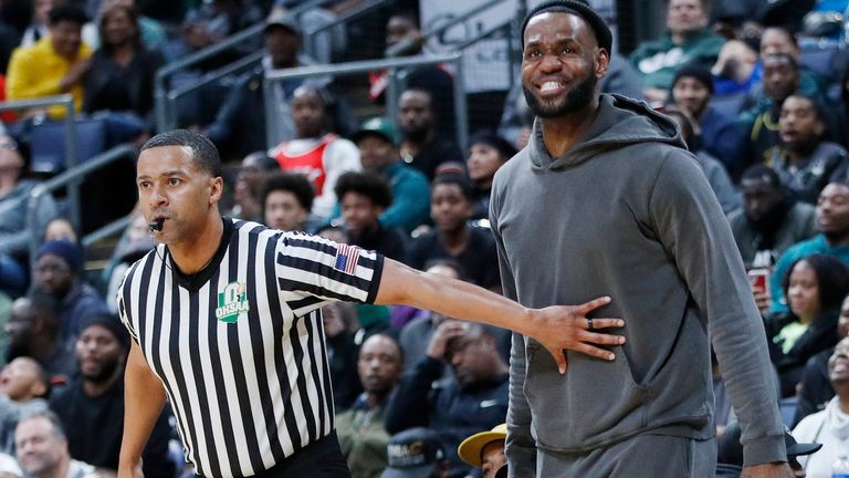 James is held back by a referee as his son Bronny makes the game-clinching layup for the Sierra Canyon Trailblazers on Saturday