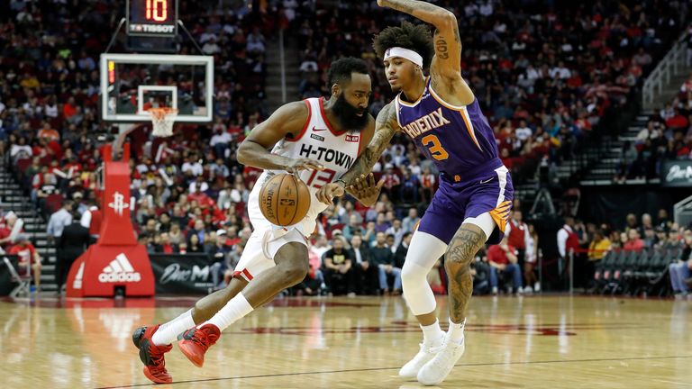James Harden of the Houston Rockets drives to the basket defended by Kelly Oubre Jr. of the Phoenix Suns