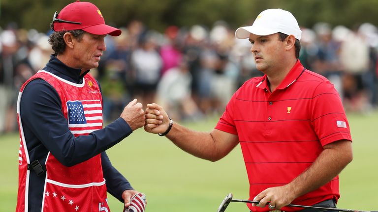 Patrick Reed of the United States team and his caddie and swing coach Kevin Kirk bump fists on the first hole during Sunday Singles matches on day four of the 2019 Presidents Cup at Royal Melbourne Golf Course 