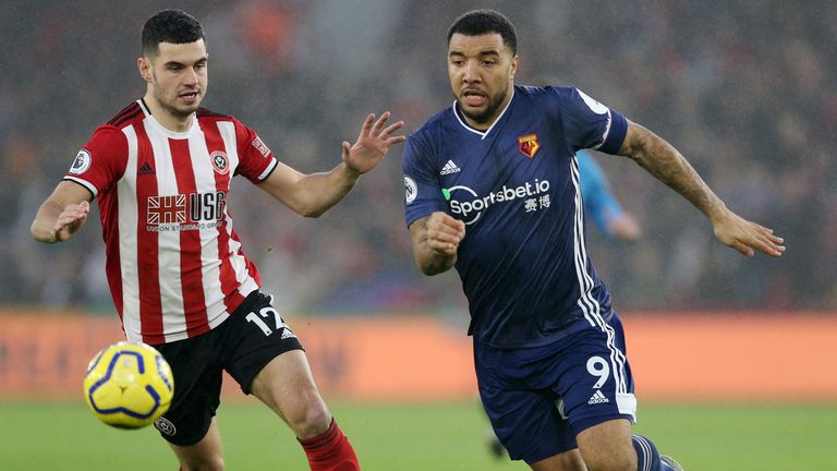 Troy Deeney challenges for the ball with John Egan