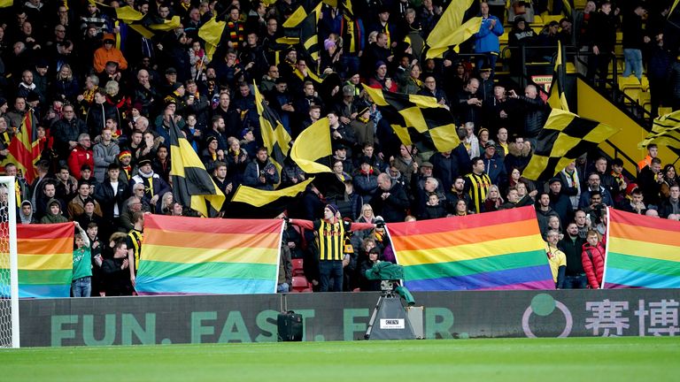 Watford fans hold up Rainbow flags before the Premier League match at Vicarage Road, Watford. PA Photo. Picture date: Saturday December 7, 2019. See PA story SOCCER Watford. Photo credit should read: Tess Derry/PA Wire. RESTRICTIONS: EDITORIAL USE ONLY No use with unauthorised audio, video, data, fixture lists, club/league logos or "live" services. Online in-match use limited to 120 images, no video emulation. No use in betting, games or single club/league/player publications.