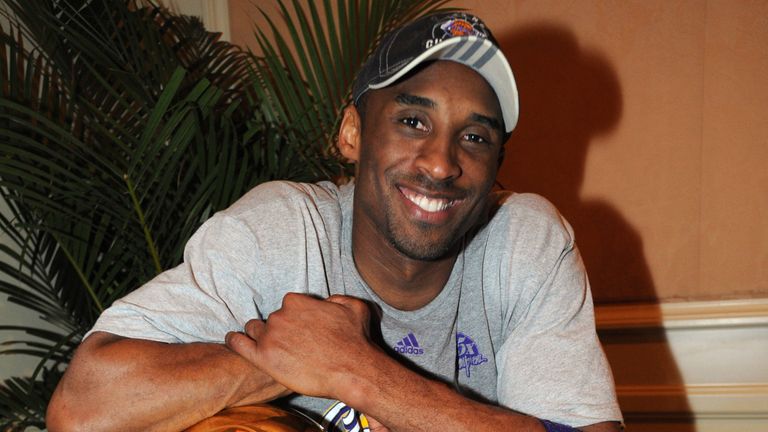 Kobe Bryant poses with the NBA championship and NBA Finals MVP trophies