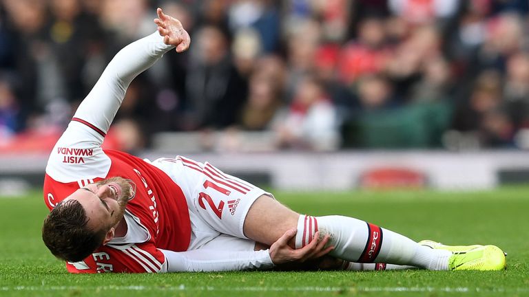Arsenal's Calum Chambers holds his knee after picking up an injury