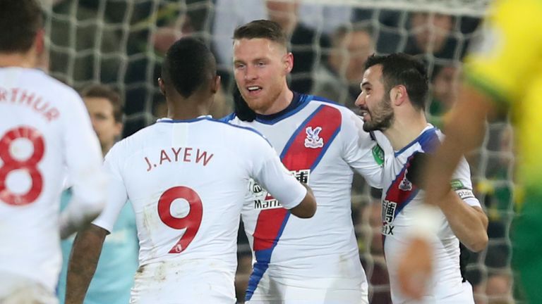 Wickham is mobbed by his team-mates after his goal was allowed to stand