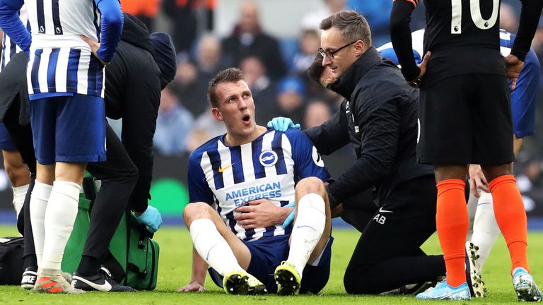 Brighton and Hove Albion's Dan Burn receives treatment before being substituted with an injury during the Premier League match against Chelsea at the AMEX Stadium
