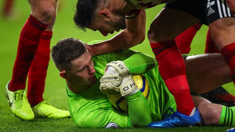 Dean Henderson holds onto the ball after saving a penalty taken by Gabriel Jesus