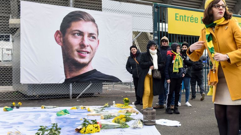 People pay homage and lay flowers in front of a portrait of Nantes' Argentinian forward Emilianio Sala, who died one year ago in a plane crash
