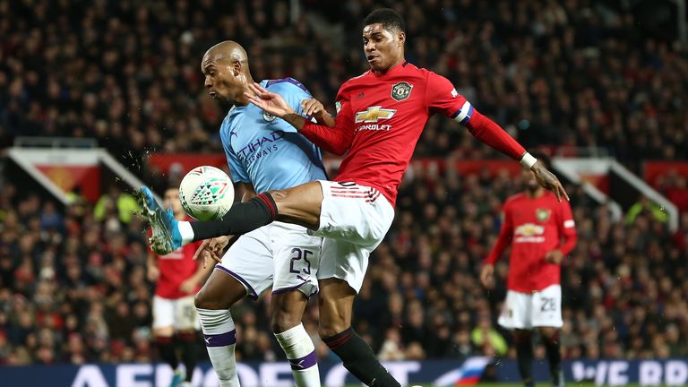 Fernandinho and Marcus Rashford compete for the ball during the Carabao Cup semi-final first leg between Manchester City and Manchester United at Old Trafford