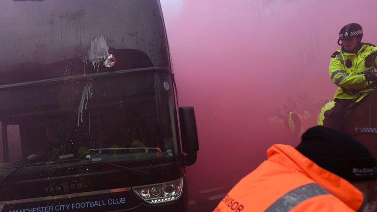 The Manchester City coach was damaged after bottles and cans were thrown at it