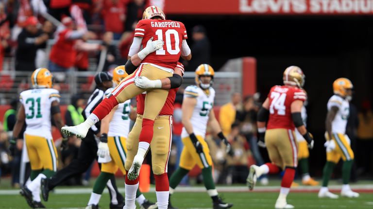 Jimmy Garoppolo of the San Francisco 49ers reacts to a touchdown run by Raheem Mostert in the first quarter against the Green Bay Packers during the NFC Championship game