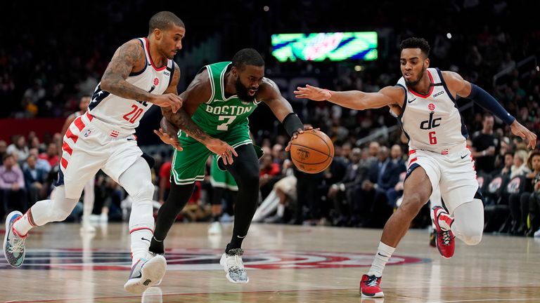 Jaylen Brown of the Boston Celtics dribbles the ball as Gary Payton II and Troy Brown Jr. of the Washington Wizards