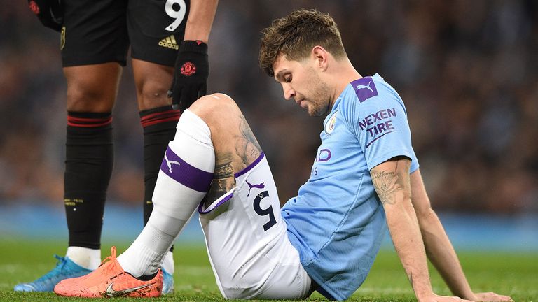 Manchester City&#39;s English defender John Stones (R) sits on the pitch injured before being substituted during the English Premier League football match between Manchester City and Manchester United at the Etihad Stadium in Manchester, north west England, on December 7, 2019.