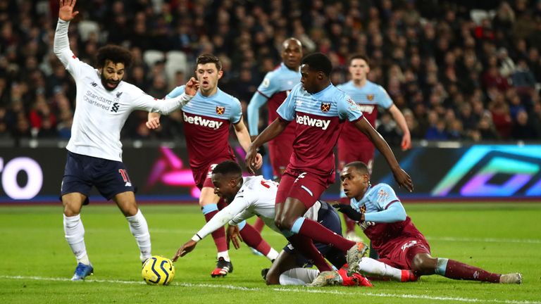 Divock Origi goes down inside the box under a challenge from Issa Diop