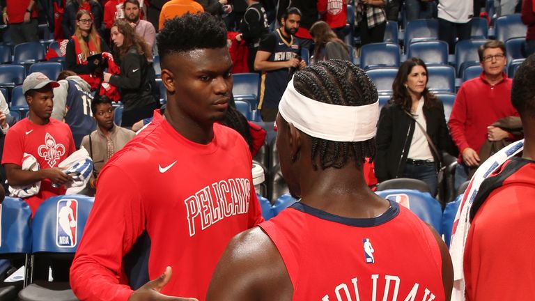 Zion Williamson and Jrue Holiday share a moment courtside