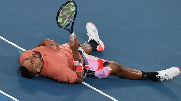 Australia's Nick Kyrgios falls on the court after hitting a return against Spain's Rafael Nadal during their men's singles match on day eight of the Australian Open tennis tournament in Melbourne on January 27, 2020