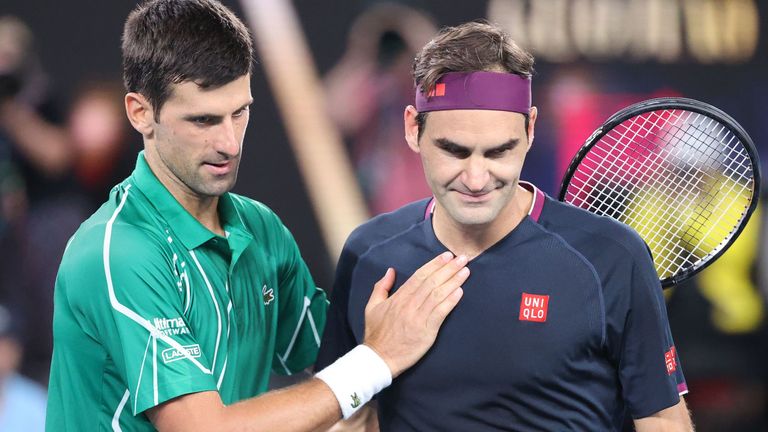 Serbia's Novak Djokovic (L) pats Switzerland's Roger Federer after his victory during their men's singles semi-final match on day eleven of the Australian Open tennis tournament in Melbourne on January 30, 2020