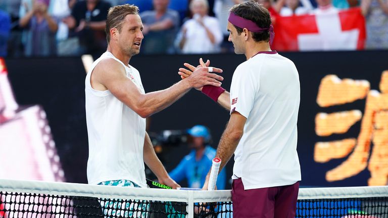 Roger Federer of Switzerland and Tennys Sandgren of the United States embrace at the net following their Men’s Singles Quarterfinal match on day nine of the 2020 Australian Open at Melbourne Park on January 28, 2020 in Melbourne, Australia.