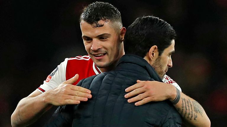 Arsenal's Swiss midfielder Granit Xhaka (L) and Arsenal's Spanish head coach Mikel Arteta (R) embrace on the pitch after the English FA Cup third round football match between Arsenal and Leeds United at The Emirates Stadium in London on January 6, 2020. - Arsenal won the game 1-0. 