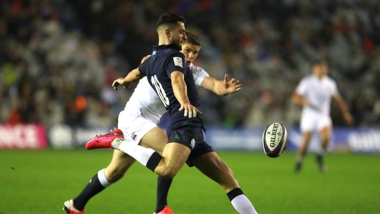 Adam Hastings kicks under pressure from Owen Farrell