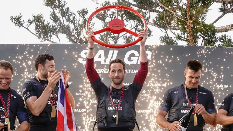 Ben Ainslie, helmsman, lifts the winning trophy as Iain Jensen, Luke Parkinson, Matt Gotrel, Neil Hunter and Richard Mason of Great Britain SailGP Team celebrate winning SailGP Sydney on Race Day 2