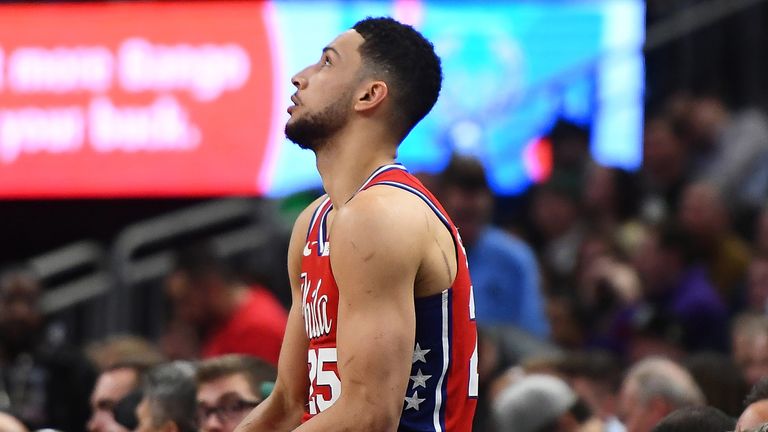 Ben Simmons waits at the scorer's table before entering the game in Milwaukee