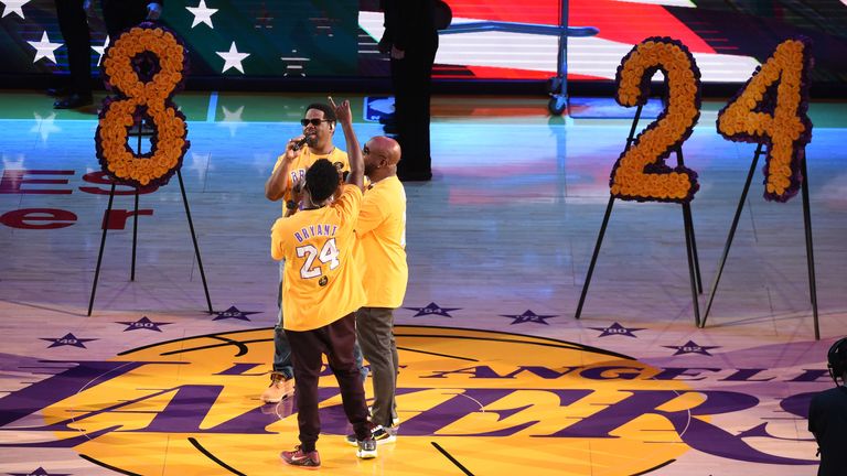 Boyz II Men perform the national anthem flanked by floral tributes to Kobe Bryant