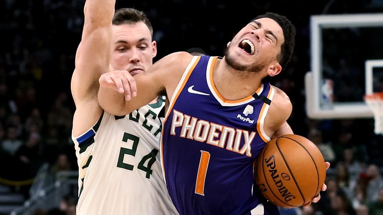 Devin Booker absorbs contact during the Suns&#39; loss to the Bucks