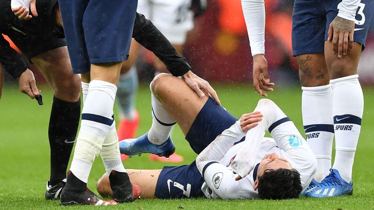Heung-Min Son holds his right arm following a collision with an Aston Villa player on Sunday