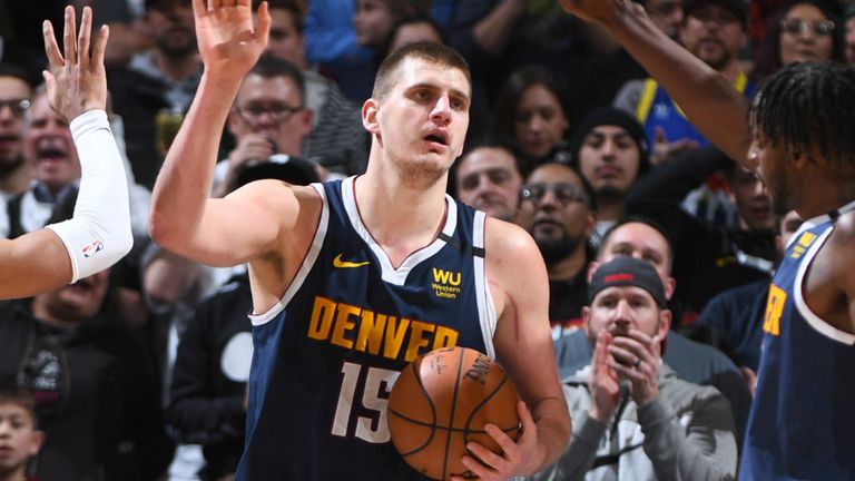 Nikola Jokic high-fives his Nuggets team-mates