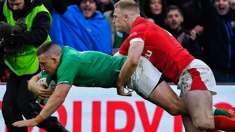 Andrew Conway dives over to score Ireland's fourth try despite the tackle of Johnny McNicholl of Wales