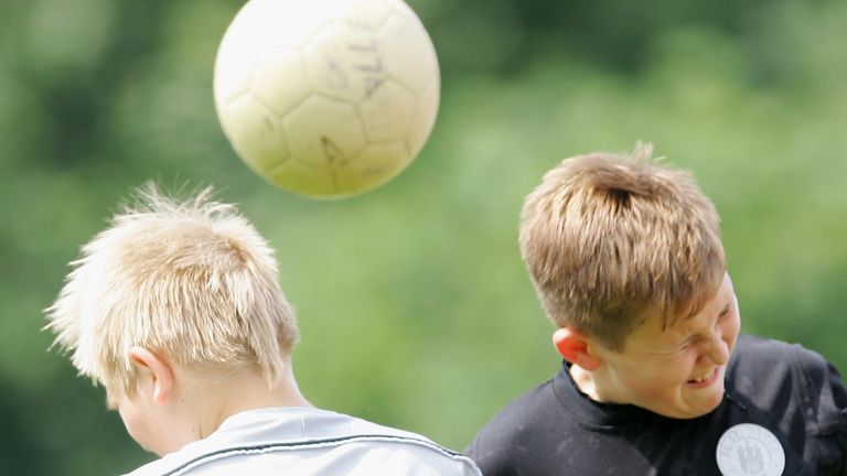 Stock image of boys heading a football