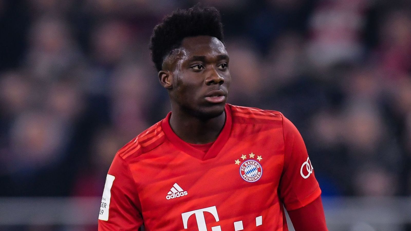  Alphonso Davies, a Bayern Munich player, looking intensely while playing soccer during a game.
