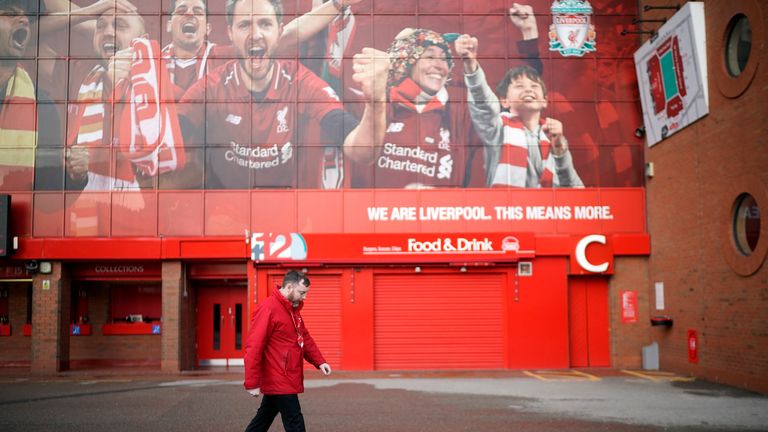 A steward walks outside Liverpool's ground Anfield.