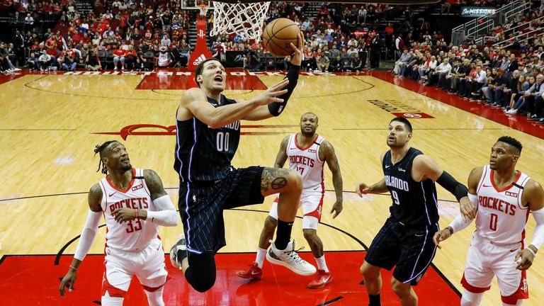 Aaron Gordon of the Orlando Magic drives to the basket while defended by Robert Covington of the Houston Rockets