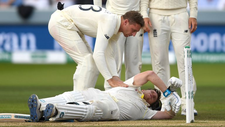 os Buttler, Jack Leech and Joe Root of England check on Steven Smith of Australia as he lies on the ground after been hit in the head by a ball from Jofra Archer of England during day four of the 2nd Specsavers Ashes Test match at Lord's Cricket Ground on August 17, 2019 in London, England. 