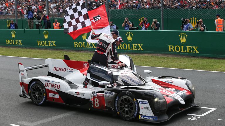  Sebastien Buemi of Switzerland and Toyota Gazoo Racing and Fernando Alonso of Spain and Toyota Gazoo Racing celebrate as Kazuki Nakajima of Japan and Toyota Gazoo Racing drives into parc ferme at the end of the race during the 24 Hours of Le Mans