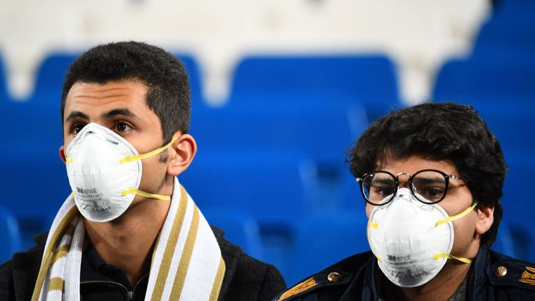 Two fans are pictured wearing masks during El Clasico