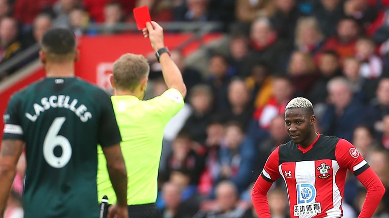 Referee Graham Scott shows Moussa Djenepo a red card following a VAR review for a challenge on Isaac Hayden