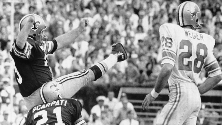 New Orleans: Record Kick. Saints field goal expert Tom Dempsey watches one of his kicks split the uprights during first half action here Nov. 8th, as safety Joe Scarpati holds and Lions' safety Mike Weger watches. Dempsey kicked four field goals---the final and most exciting with two seconds left, a record 63 yards to give the Saints a come-from-behind-victory of 19-17. Dempsey was born without a right foot. He was fitted with an artificial foot in childhood