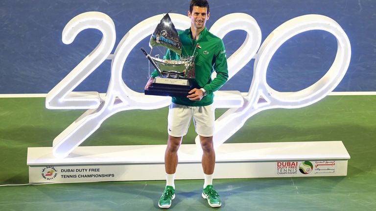 Novak Djokovic of Serbia poses with the victor's trophy after winning the final of the Dubai Duty Free Tennis Championship in the Gulf emirate of Dubai on February 29, 2020